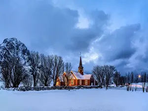 Lofoten Prints: Threatening clouds at dusk contrast with the warm colors of the church of Flakstad