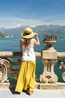 Admiring Gallery: Tourist admiring Como lake view from the balcony of villa del Balbianello on punta