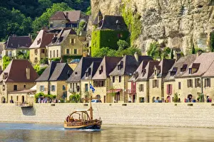 Rows Prints: Tourist boat passing in front of old stone houses on Dordogne River in late afternoon