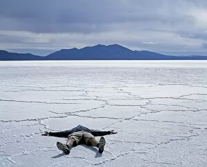 Salt Lake Gallery: A tourist lies on the salt crust of the Salar de Uyuni