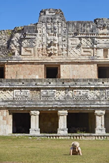 A tourist looking at the ancient Mayan town of Uxmal, Yucatan, Mexico. The ruins of Uxmal have been declared a UNESCO
