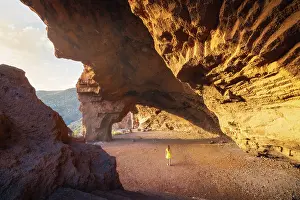 Cave Prints: A tourist observes Cueva Roja at sunset