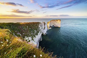 Purbeck Prints: A tourist observes sunset at Old Harry Rocks during summer