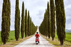 Images Dated 13th November 2017: Tourist riding an italian vespa motorcycle in the countryside. Val d Orcia, Tuscany