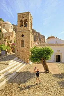 Tourist Taking Photograph of The Church of Elkomenos Christos and Bell Tower in Platia