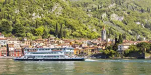 A touristic ferry crossing Lake Como with the village of Varenna in the background