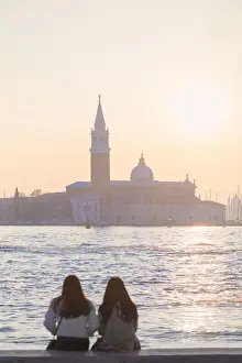 Watch Prints: two tourists admire the sunset towards the island of San Giorgio maggiore from