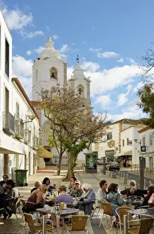 Tourists at a cafe and the church of Santo Antonio. Lagos Portugal