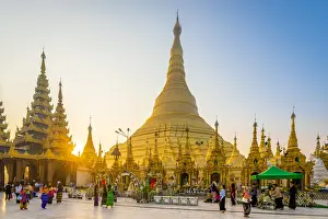 Stupas Prints: Tourists at gilded Shwedagon Pagoda against clear sky at sunrise, Yangon, Yangon Region
