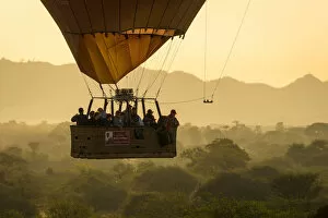 Aircraft Gallery: Tourists in a hot air balloon basket flying over vegetation, UNESCO, Bagan, Myanmar