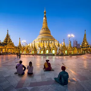 Tourists Gallery: Tourists praying at the Shwedagon Pagoda in Yangon, Yangon Region, Myanmar