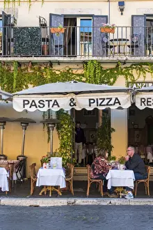 Pizzeria Prints: Tourists seated at table outside a pizzeria restaurant in Piazza Navona, Rome, Lazio