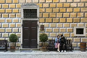 Bench Prints: Tourists sitting on a bench at premises of Cesky Krumlov Castle and Chateau