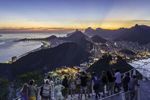 Tourists viewing Christ the Redeemer on Mount Corcovado and the city at sunset