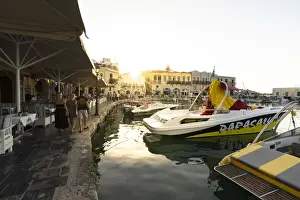 Greek Culture Prints: Tourists walking on waterfront at sunset in the old Venetian harbour of Rethymno