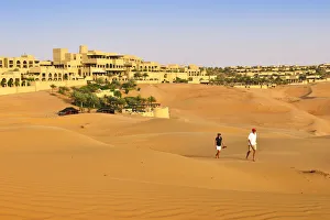 Images Dated 13th January 2015: Tourists wander through dunes outside the desert luxury hotel Anantara Qasr Al Sarab