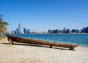 Traditional boat in the Heritage Village with city skyline in the background, Abu Dhabi