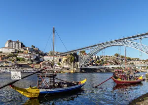 Traditional boats on Vila Nova de Gaia bank of Douro River, Dom Luis I Bridge in