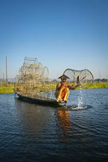 Fish Gallery: Traditional fisherman fishing on Lake Inle using cylinder fishing nets, Lake Inle