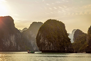 Northeast Vietnam Prints: Traditional fishing boat and limestone islands at dawn, Halong Bay, Northeast Vietnam