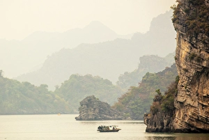 Northeast Vietnam Prints: Traditional fishing boat and limestone islands at dawn, Halong Bay, Northeast Vietnam