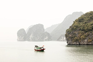 Northeast Vietnam Prints: Traditional fishing boat and limestone islands at dawn, Halong Bay, Northeast Vietnam