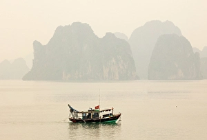 Northeast Vietnam Prints: Traditional fishing boat and limestone islands at dawn, Halong Bay, Northeast Vietnam
