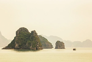 Northeast Vietnam Prints: Traditional fishing boat and limestone islands at dawn, Halong Bay, Northeast Vietnam