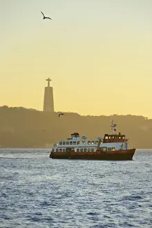 A traditional passenger boat (cacilheiro) crossing the Tagus river between Almada