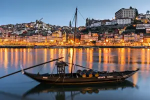 Ribeira Prints: Traditional Rabelo boat designed to carry wine down Douro river with city skyline behind