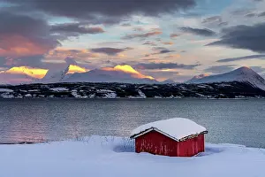 Fjord Prints: Traditional red cabin covered with snow overlooking the fjord