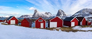 Mountain Peak Prints: Traditional red cabins on a beach covered wih snow, Rodsand, Senja, Troms county, Norway