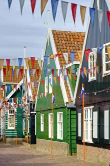 Traditional wooden houses decorated with flags of Dutch national colors for Koningsdag Traditional wooden houses decorated with flags of Dutch national colors for Koningsdag