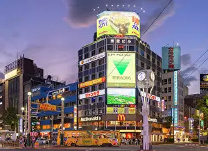 Sapporo Prints: Tram passing neon signs on side of buildings, Susukino, Sapporo, Hokkaido, Japan