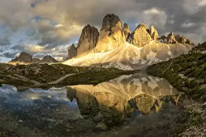Summer Colours Prints: Tre Cime di Lavaredo are reflected in an alpine lake during a sunset with warm light