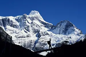 Walker Prints: Trekker crosses bridge over Rio Frances with summit of Paine Grande behind (MR)