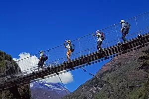 Adventurous Gallery: Trekkers crossing a suspension bridge over the Dudh Kosi river