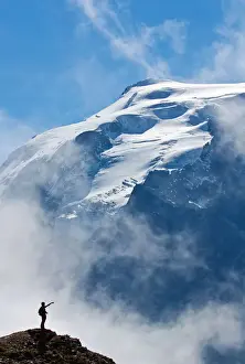 Trekkig at Stelvio pass, silhouette of an hiker facing the Ortles. Valtellina valley