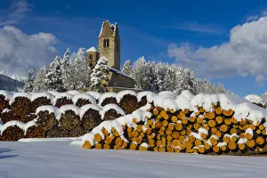 Trunks and old church in Celerina with pristine snow. Engadine, Switzerland, Europe
