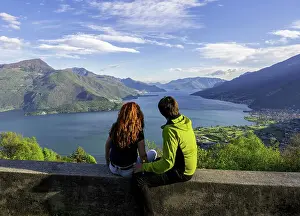 Como Prints: two turist admire lake Como, sitting on the wall of santa croce church