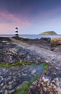 Anglesey Prints: Twilight on the rocky Anglesey coast looking towards Penmon Point Lighthouse and Puffin Island