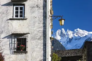 Street Lamp Prints: Typical alpine house and street lantern frame the snowy peaks Soglio Bregaglia Valley