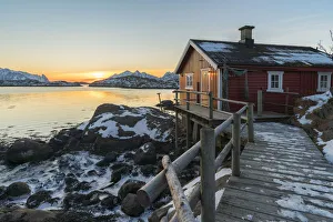 Typical fishermen red house on the sea at dawn in winter. Svolvaer, Nordland county