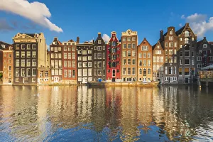 Urban Landscape Prints: Typical houses reflecting in Damrak canal at sunset, Holland / Netherlands