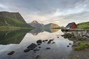 Nordland County Prints: Typical rorbu and peaks reflected in the clear sea during midnight sun, Vengeren