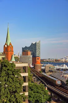 U-Bahn train on tracks with Elbephilharmonie in background, Hamburg, Germany