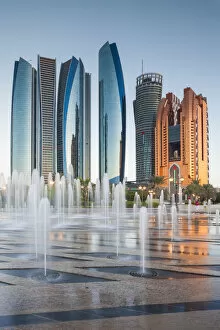 Images Dated 31st May 2016: UAE, Abu Dhabi, Etihad Towers and Emirates Palace Hotel fountains, dusk