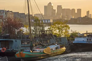 Images Dated 23rd March 2018: UK, England, London, Southwark, Canary Wharf skyline and old barges on River Thames