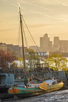 UK, England, London, Southwark, Canary Wharf skyline and old barges on River Thames