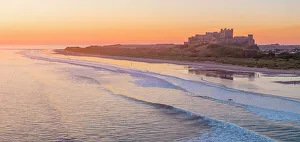 Northumbria Prints: UK, England, Northumberland, Bamburgh, Bamburgh Beach, Bamburgh Castle at sunrise